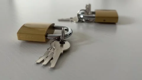 Close Up Of Brass Padlocks And Keys On White Table For Security And Protection Stock Footage 339064218