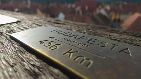 Close-up of a brass plate indicating the distance to Budapest from the Clock Stock Footage 319479462