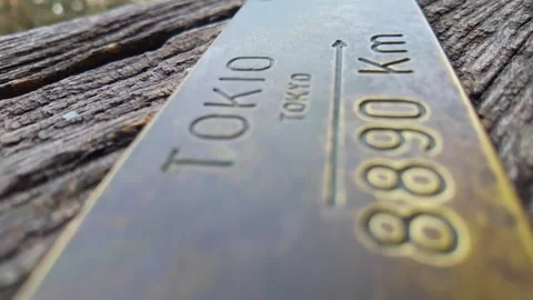 Close-up of a brass plate indicating the distance to Tokyo from the Clock Tower Stock Footage 319479469