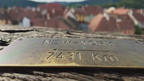 Close-up of a brass plate indicating the distance to New York from the Clock Stock Footage 319607142