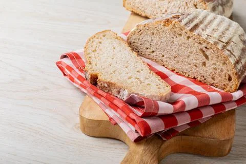 Close-up of bread with checked pattern napkin on serving board at table Stock Photos