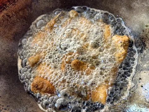 Close up of bread coated salmon fish being deep fried in pan with hot oil Stock-Fotos