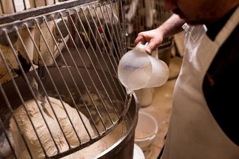 Close up bread doug preparation inside automatic dough kneading machine in br Stock Photos