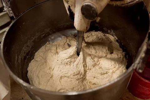 Close up bread dough preparation inside automatic dough kneading machine in b Foto stock