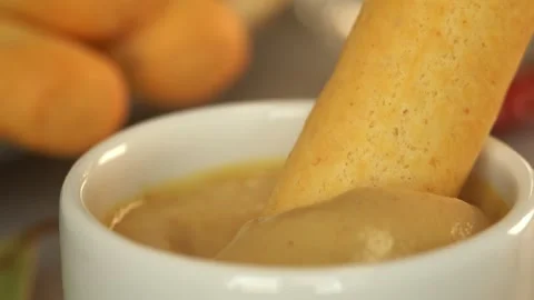 Close up of bread stick is dipped in mustard sauce. Crouton snack. Food. Bread Stock Footage 300996442
