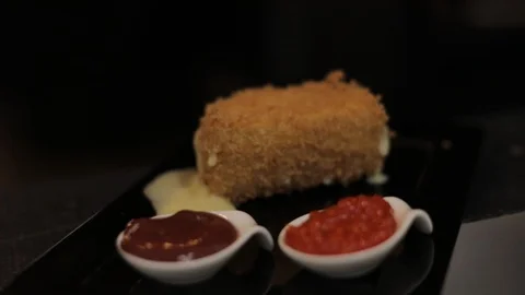 Close up of Breaded Brie Cheese with Sauces (Pepper and Ketchup) on Plate Stock Footage 129337887