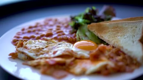 Close-up of a breakfast of eggs, tomatoes, ham, beans, lettuce and toast Stock Footage 223840655