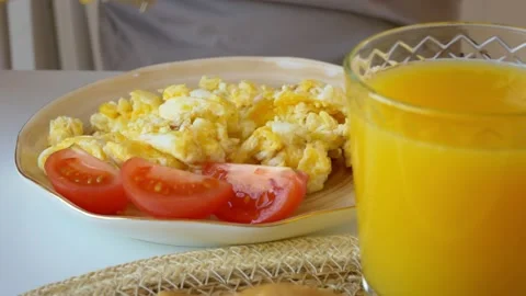 Close-up breakfast of fried eggs with cheese sauce and fresh tomatoes and orange Stock Footage 210510949