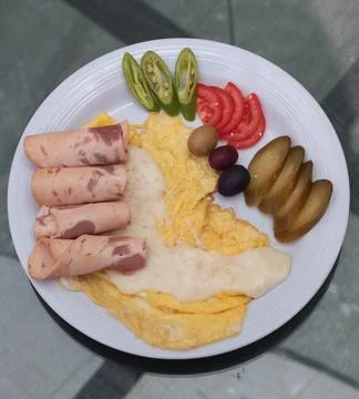 Close-up breakfast plate with scrambled eggs and ham rolls served Stock Photos