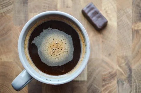 Close-up brewed coffee in a cup with candy on a wooden table. Coffee and choc Stock Photos