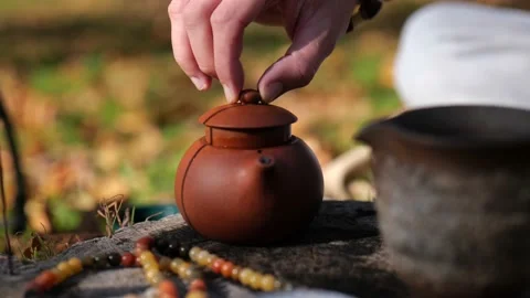 Close-up. brewed tea in a clay teapot a man closes the lid. chinese tea Видео 229859353