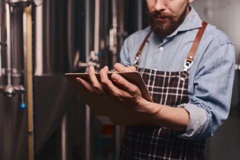 Close up of a brewery worker checking the beer storage. Stock Photos