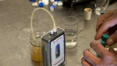 Close-up of a brewmaster measuring and testing beer samples at a microbrewery. Stock Footage 99597762
