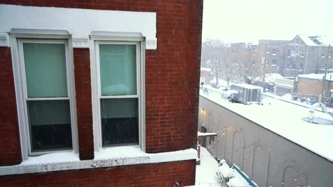 Close Up of Brick Apartment Building, Windows during Light Snowfall on Stock Footage 148343862