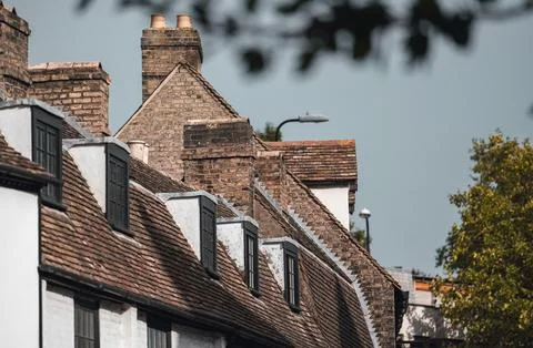 Close up of brick building with multiple chimneys and windows in London. Stock Photos