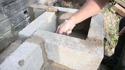 Close up of brick layer, laying concrete birck at home creating steps for garage Stock Footage 132361878