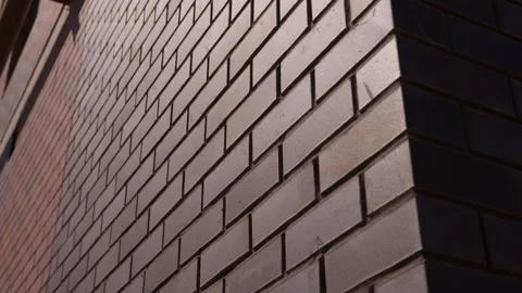 Close up of brick wall corner with sunlight and shadow Видео 347160038