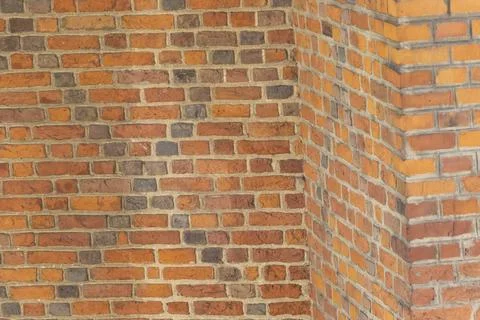 Close-up of a brick wall featuring a mix of red, brown, and gray bricks. This Stockfoto's