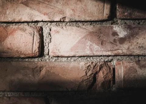 Close up of a brick wall with harsh light from the upper left and shadows on Stock Photos