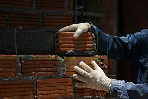 Close up of bricklayer installing bricks on construction site. Concept of repair Stock Photos