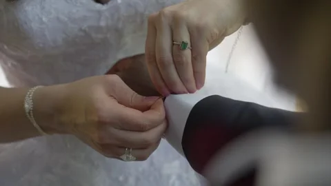 Close-up of Bride Adjusting Groom's Cufflink During Marriage Preparation Stock Footage 342477722