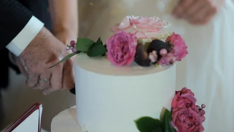 Close up of a bride and groom cutting their wedding cake. Stock Footage 101902553