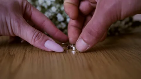 Close-up of the bride and groom's hands taking their wedding rings from Stock Footage 243563626