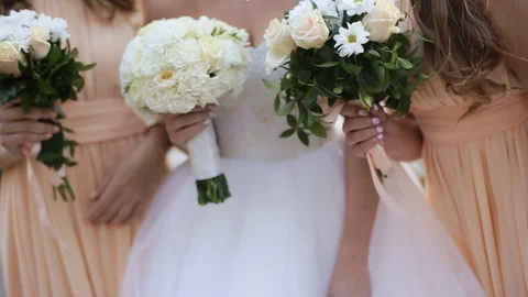 Close up of bride and her friends holding beautiful flowers in their hands Stock Footage 73925442