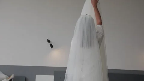 Close-up of a bride back view touching gently a white satin wedding dress Stock Footage 321662892