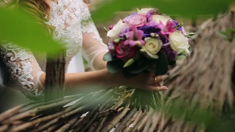 Close-up bride with bouquet in hands in park. Close up Stock Footage 100522363