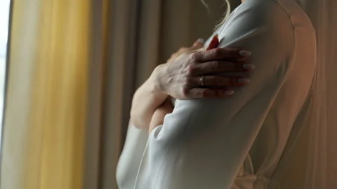 Close up of a bride in an elegant white wedding dress gently holding her arm Stock Footage 346790238