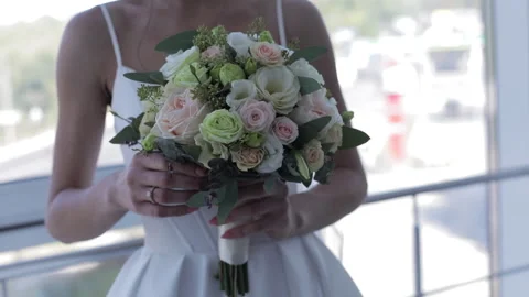 A close-up of the bride in her wedding attire, holding a luxurious bouquet and Stock Footage 321963643