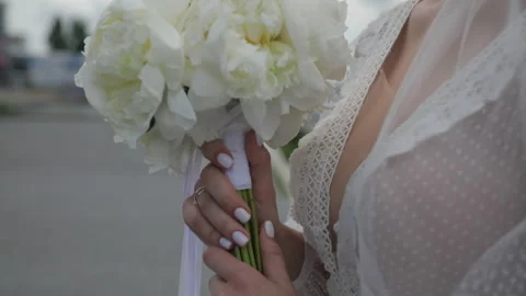 A close-up of a bride in her wedding attire holding a luxurious, delicate Stock Footage 324814682