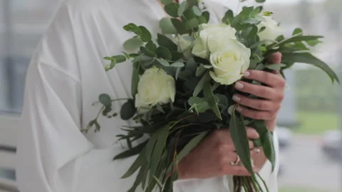 Close up of bride holding rustic bouquet in white robe and delicate engagement Stock Footage 321492031
