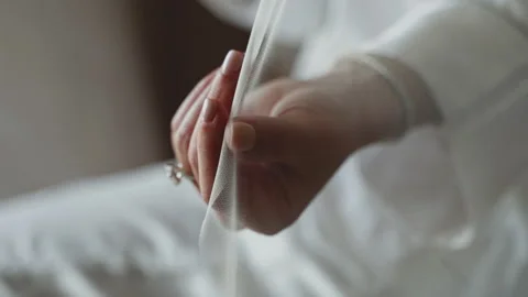 Close-up of bride's hand with engagement ring on her finger touching the veil Stock Footage 219296936