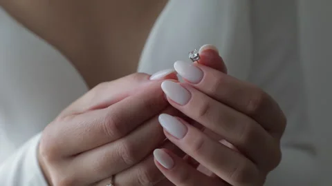 A close-up of the brides hands with an engagement ring, dressed in her wedding Stock Footage 321897122