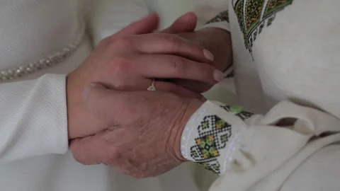 A close-up of the brides hands resting on the mature hands of her mother and Stock Footage 321831309