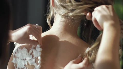 Close-up of the bridesmaid's hand buttoning the wedding dress. Vídeos de archivo 159331522