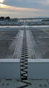 Close-up of bridge expansion joint with zigzag metal plates and concrete su.. Foto stock