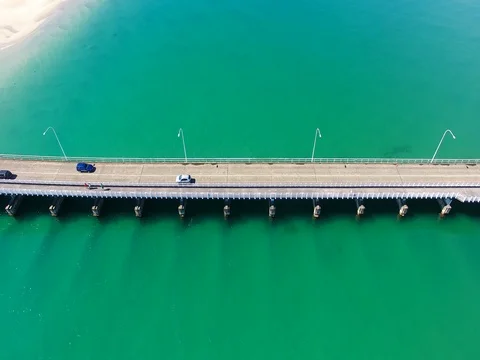 Close up of a bridge over a massive body of beautiful water Stock Footage