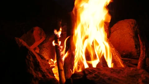 Close-Up of Bright Campfire Flames Between Stones. Night Forest Camping Scene. 動画素材 335681788