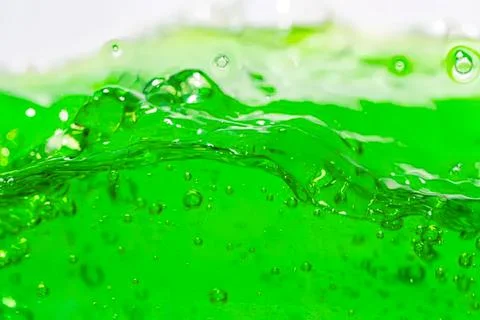 Close-up of bright green liquid with bubbles and splashes Stock Photos