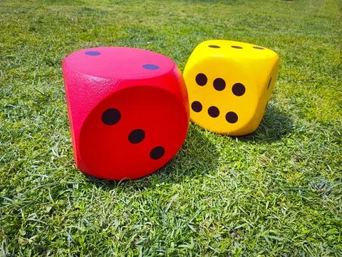 Close-up of bright large dice on the grass. Chances of winning in gambling games Foto stock