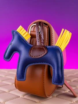 Close-up of a bright leather keychain in the shape of a blue horse with a sad Foto stock