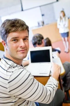Close-up of a bright male student using a laptop during a university lesson 写真素材
