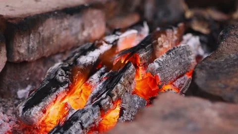 Close-up is a bright orange campfire flame  and a campfire for hiking on foot. Video stock 159878047