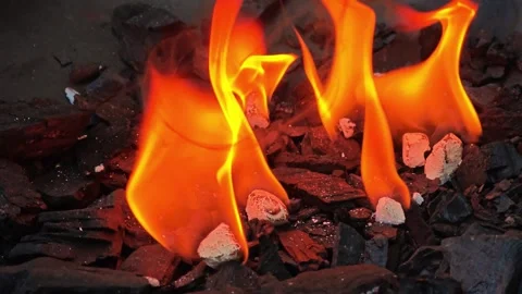 Close-Up of Bright Orange Flame Over Burning Charcoal and Embers, Intense H.. 库存影片 347986178