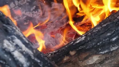 Close-up of bright orange flames and glowing charcoal embers burning in a rustic Stock Footage 338210811