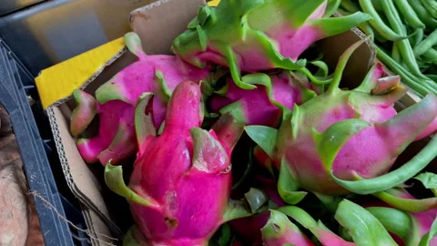 Close up of bright pink dragon fruit piled in a crate, fresh exotic texture and Stockbeeldmateriaal 324707730
