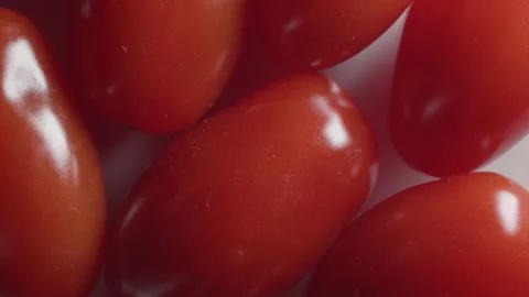 Close up of bright red cherry tomatoes on white plate - macro. 4K locked tripod Stock Footage 153765285